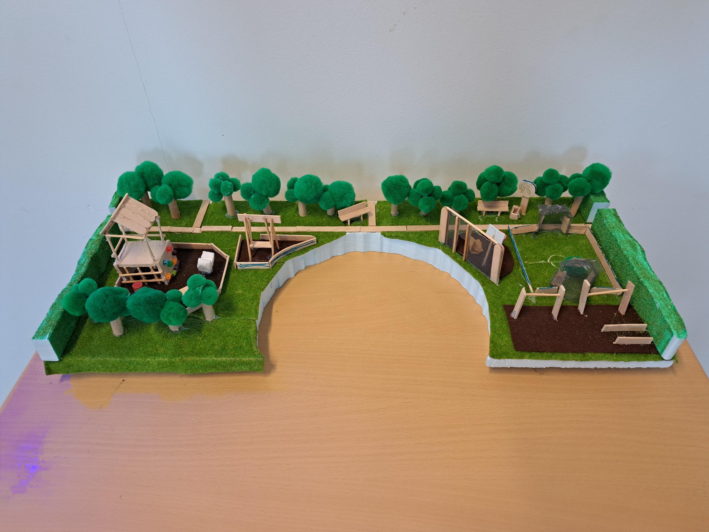 Maquette 1: rekstokken, speelhuisje, voetbalveld, bankjes en een basketbalveld