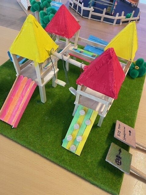Maquette 4: Groot speeltoestel met glijbanen, 4 torentjes, schommels en een brug.